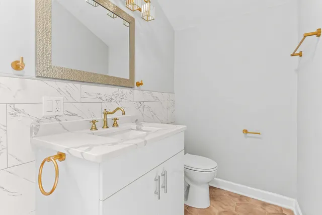 a bathroom with a sink a toilet and a mirror