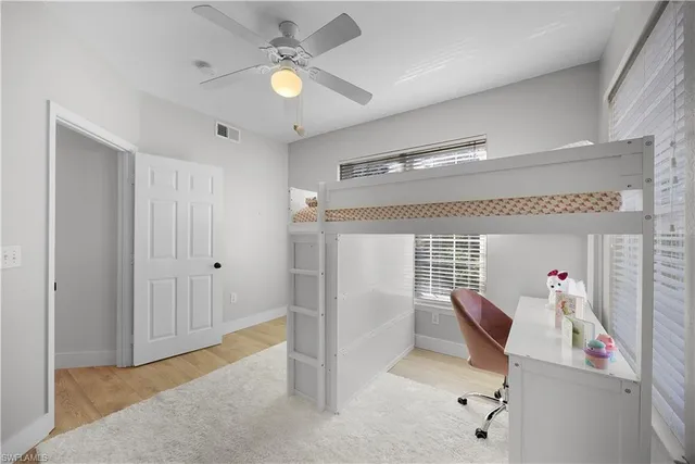 a view of a hallway with workspace and a window