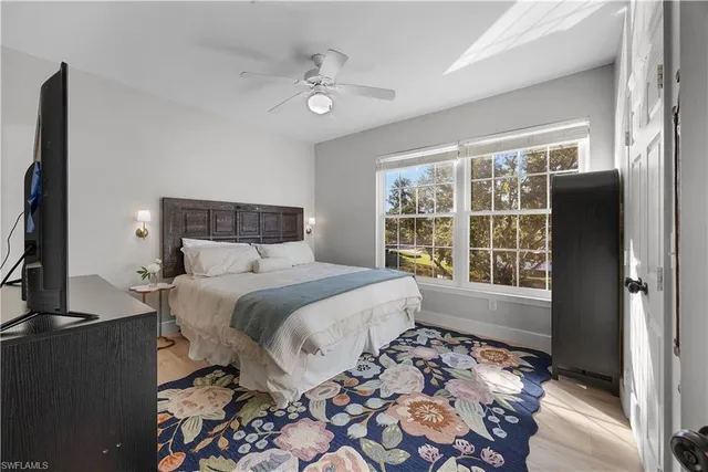 a bedroom with a bed and a flat tv screen next to a window