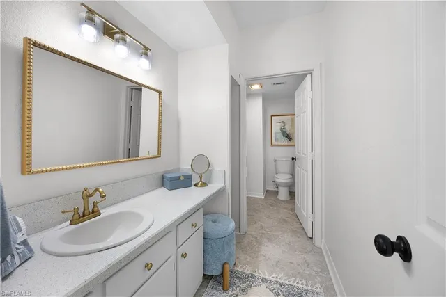 a bathroom with a double vanity sink mirror and toilet