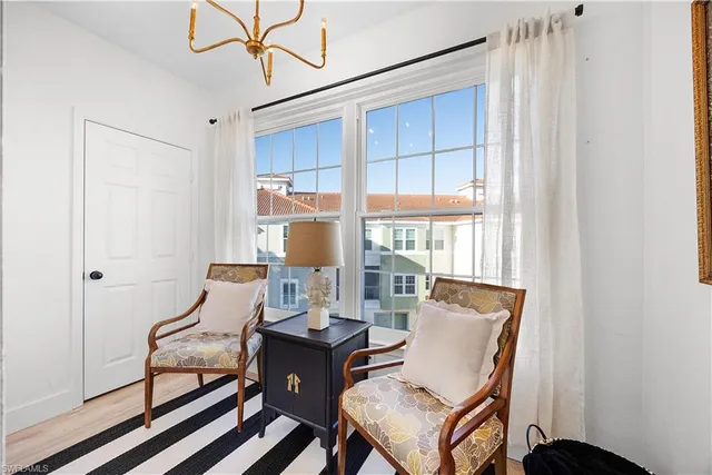 a living room with furniture a flat screen tv and a window