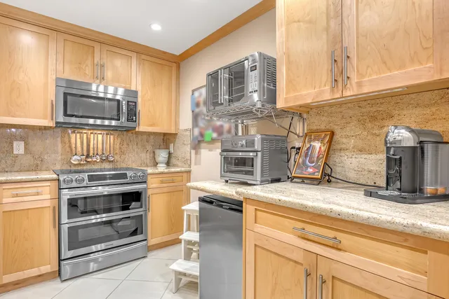 a kitchen with granite countertop a stove top oven microwave and cabinets