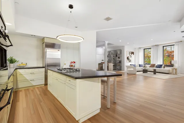 a large kitchen with kitchen island a large counter top space a sink stainless steel appliances and cabinets