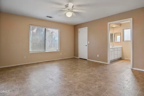 an empty room with windows and ceiling fan