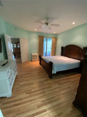 a bedroom with a bed and a flat tv screen on dresser