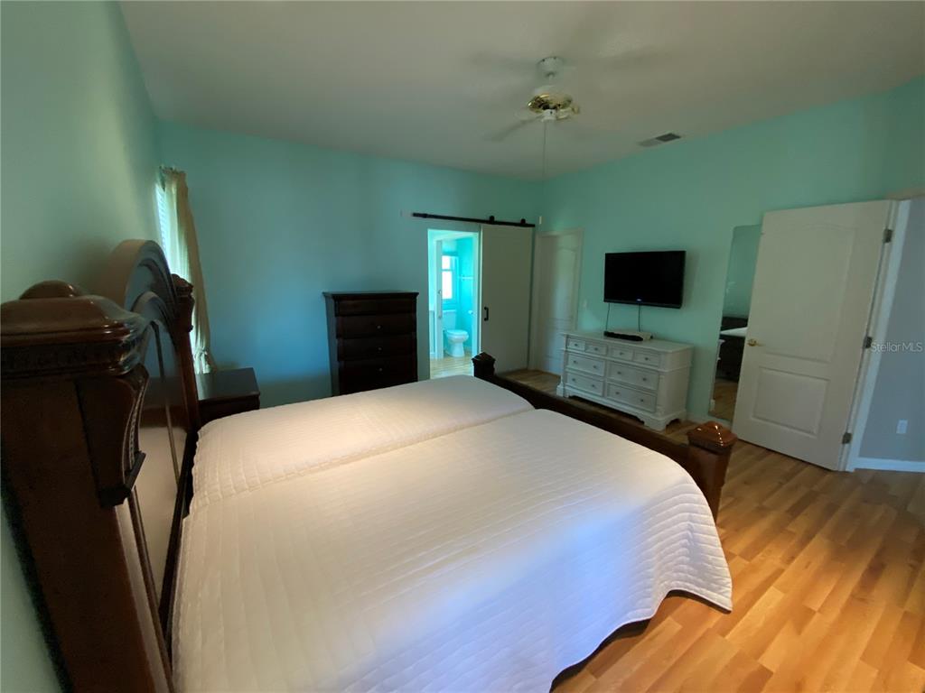 4202 Hammersmith Drive Clermont, FL 34711 - Photo 14 of 73 a bedroom with a bed and a flat tv screen on dresser