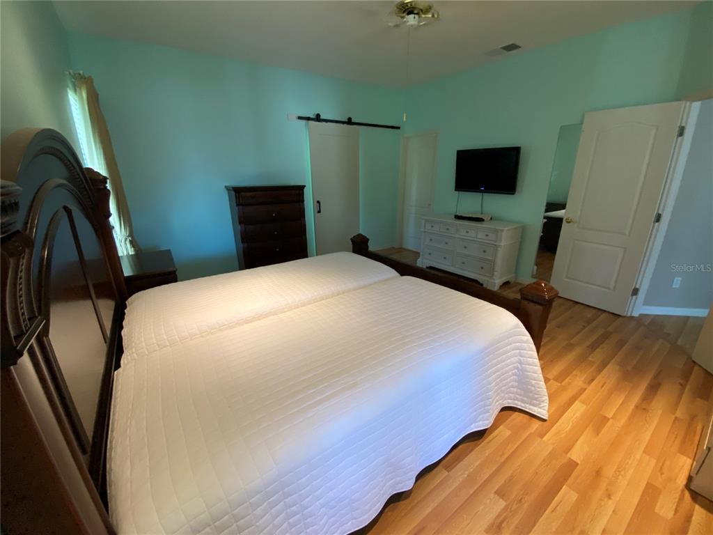 4202 Hammersmith Drive Clermont, FL 34711 - Photo 15 of 73 a bedroom with a bed and a flat tv screen on dresser
