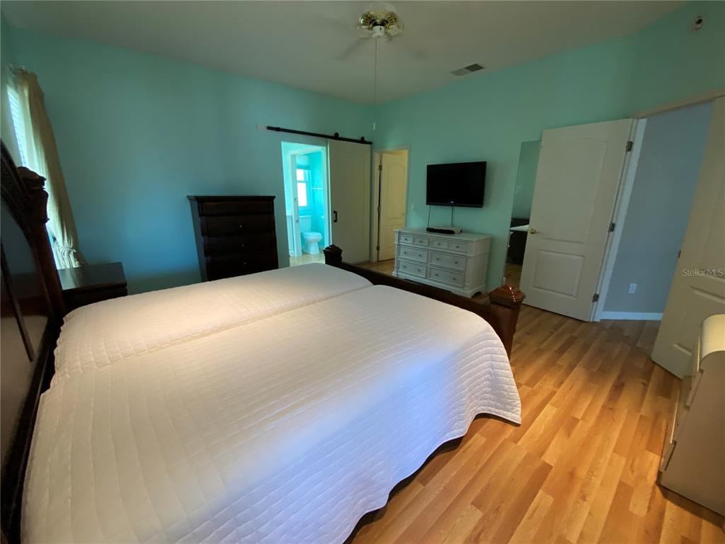 4202 Hammersmith Drive Clermont, FL 34711 - Photo 16 of 73 a bedroom with a bed and a flat tv screen on dresser