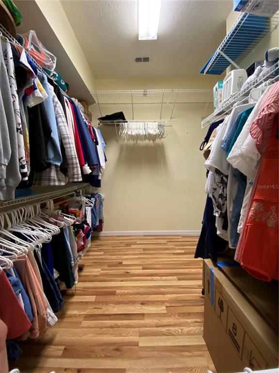 4202 Hammersmith Drive Clermont, FL 34711 - Photo 30 of 73 a view of walk in closet with clothes and shoes