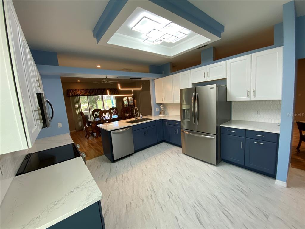 4202 Hammersmith Drive Clermont, FL 34711 - Photo 38 of 73 a kitchen with stainless steel appliances a refrigerator a sink a stove a washer dryer and a dining table