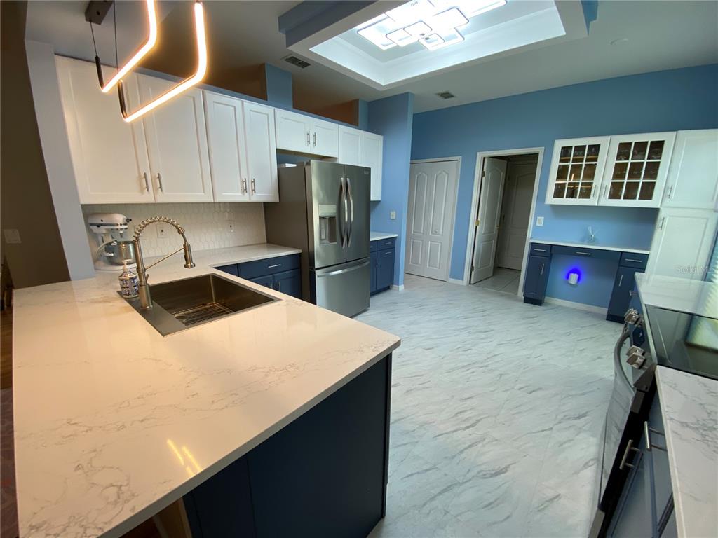 4202 Hammersmith Drive Clermont, FL 34711 - Photo 40 of 73 a kitchen with stainless steel appliances a refrigerator a sink a stove and island