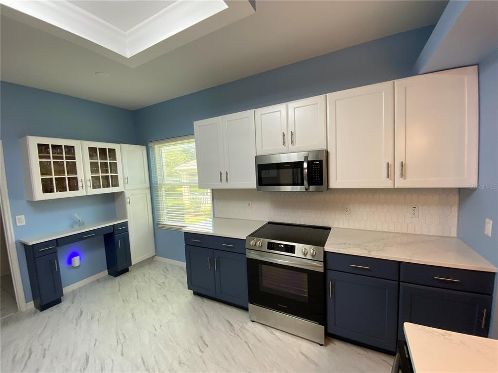 4202 Hammersmith Drive Clermont, FL 34711 - Photo 41 of 73 a kitchen with stainless steel appliances granite countertop a refrigerator and a stove top oven