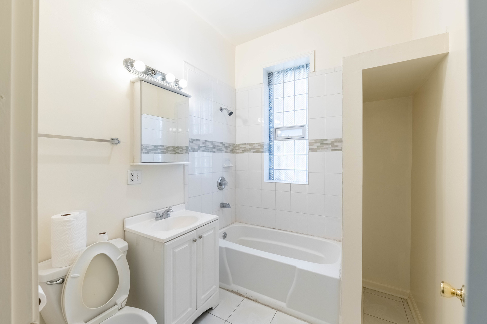 4823 South Indiana Avenue Chicago, IL 60615 - Photo 13 of 30 a bathroom with a sink toilet vanity and bathtub