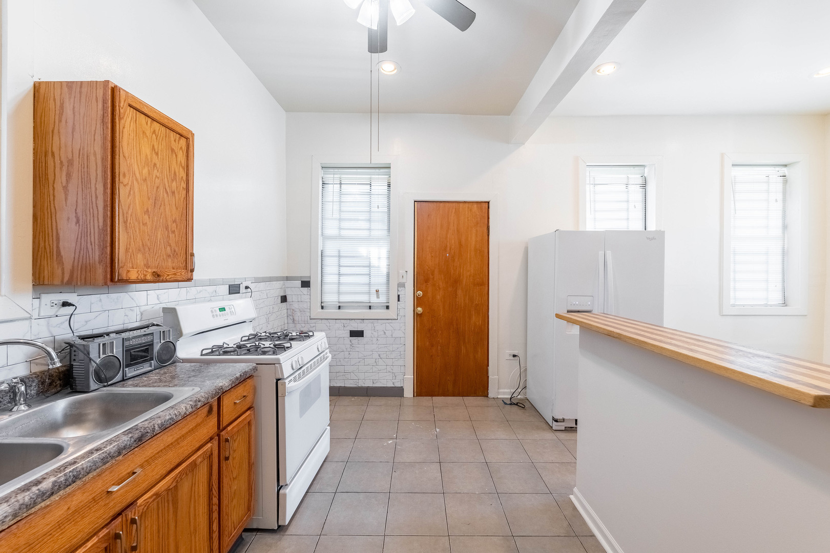 4823 South Indiana Avenue Chicago, IL 60615 - Photo 15 of 30 a kitchen with stainless steel appliances granite countertop a sink stove and refrigerator