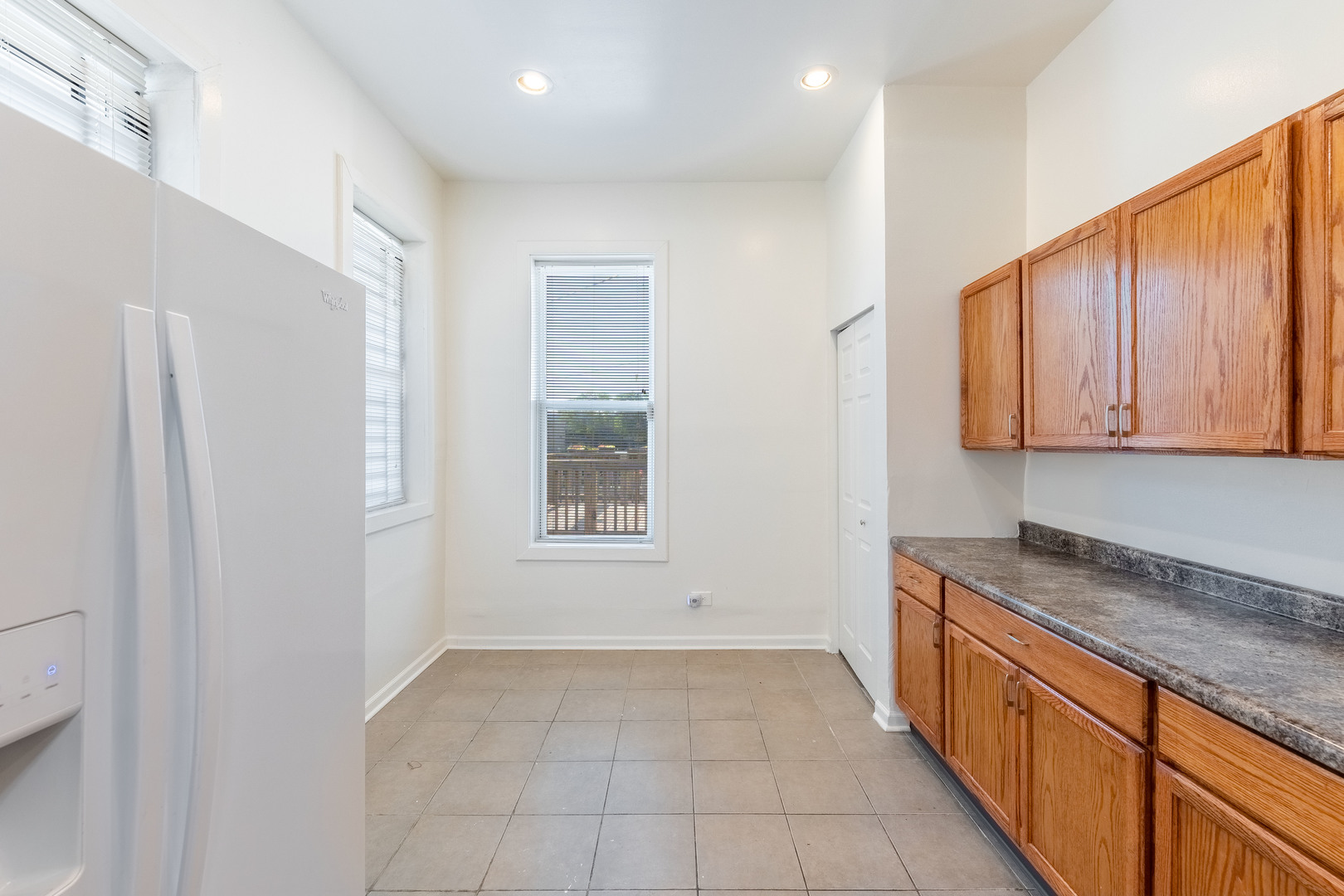 4823 South Indiana Avenue Chicago, IL 60615 - Photo 19 of 30 a large white kitchen with granite countertop a refrigerator and a sink