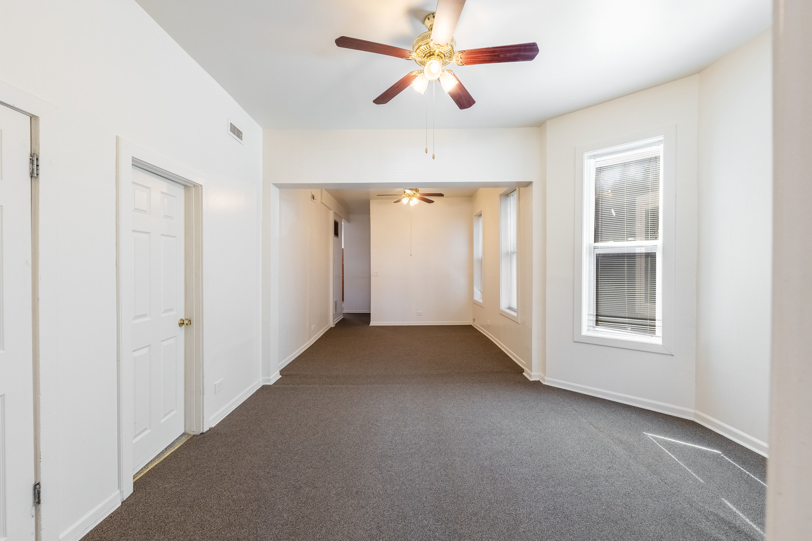 4823 South Indiana Avenue Chicago, IL 60615 - Photo 4 of 30 a view of a livingroom with a ceiling fan and window