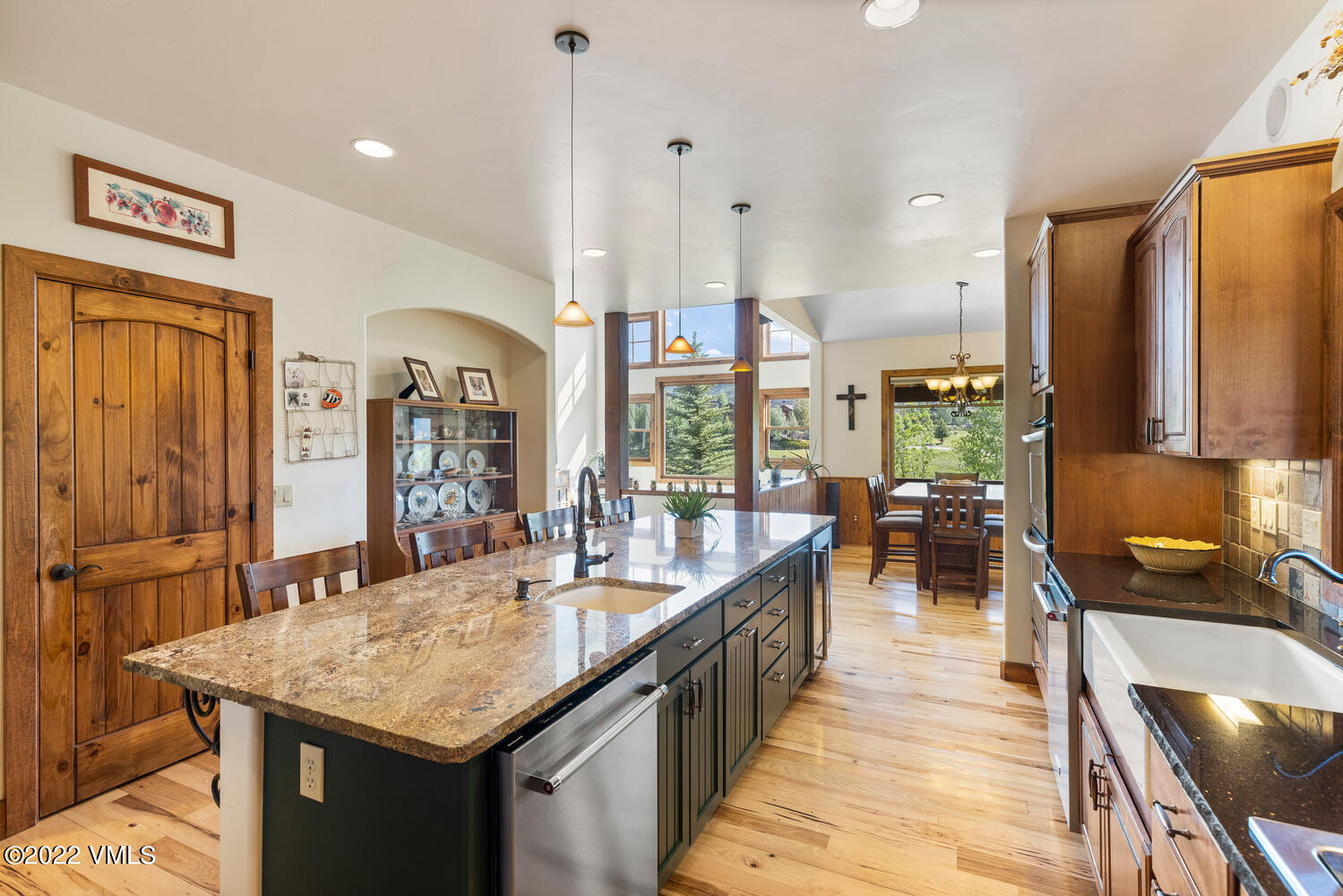 a large kitchen with kitchen island a large counter top space a sink stainless steel appliances and cabinets