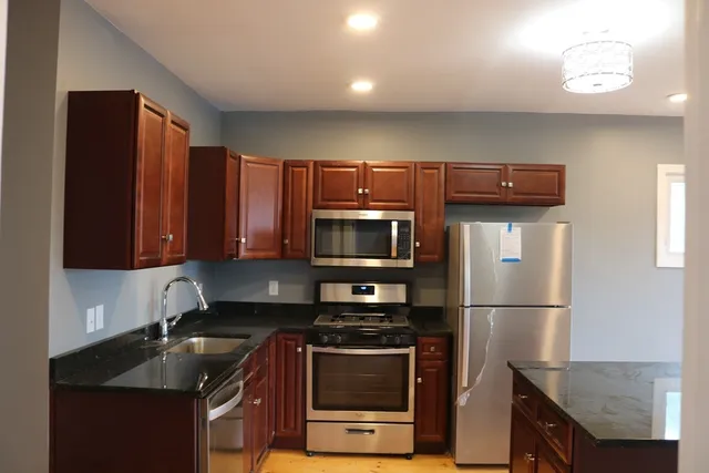 a kitchen with granite countertop a stove and a refrigerator