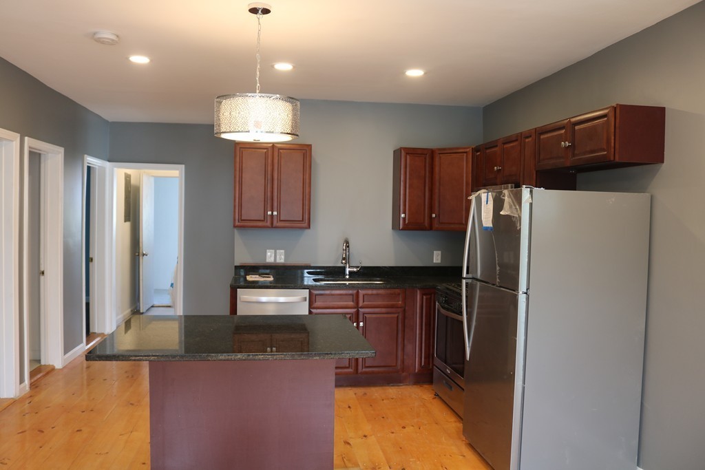 69 Catharine Street, Unit 3 Worcester, MA 01605 - Photo 3 of 17 a kitchen with stainless steel appliances granite countertop a refrigerator a stove a sink and a microwave