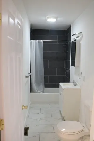 a bathroom with a toilet and a shower