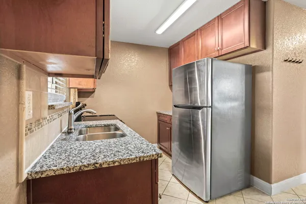 a kitchen with stainless steel appliances granite countertop a refrigerator and a sink