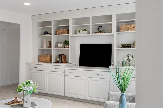 a living room with a fireplace and a potted plant