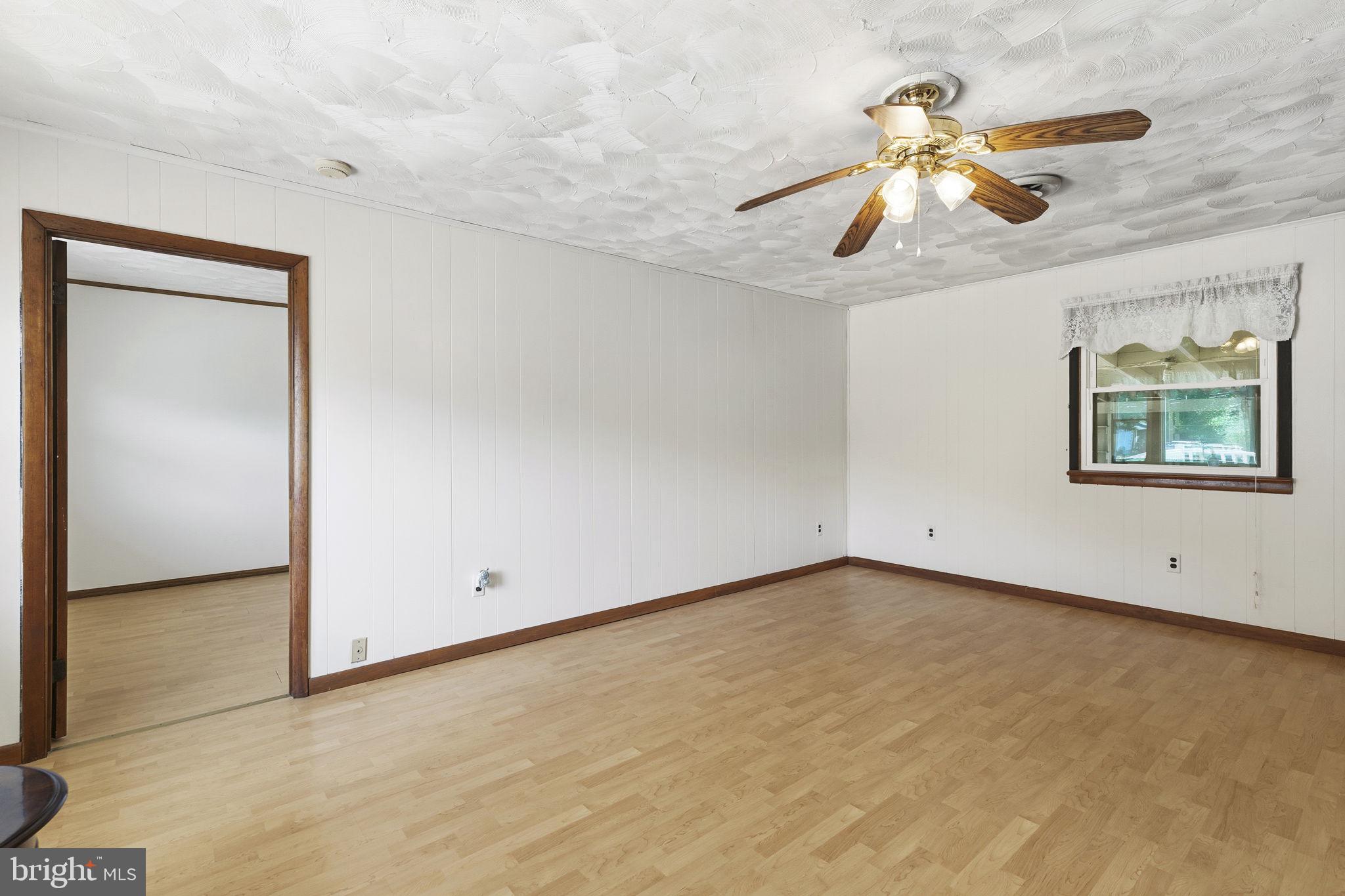 2411 Poplar Road Baltimore, MD 21221 - Photo 4 of 36 an empty room with a window and a ceiling fan