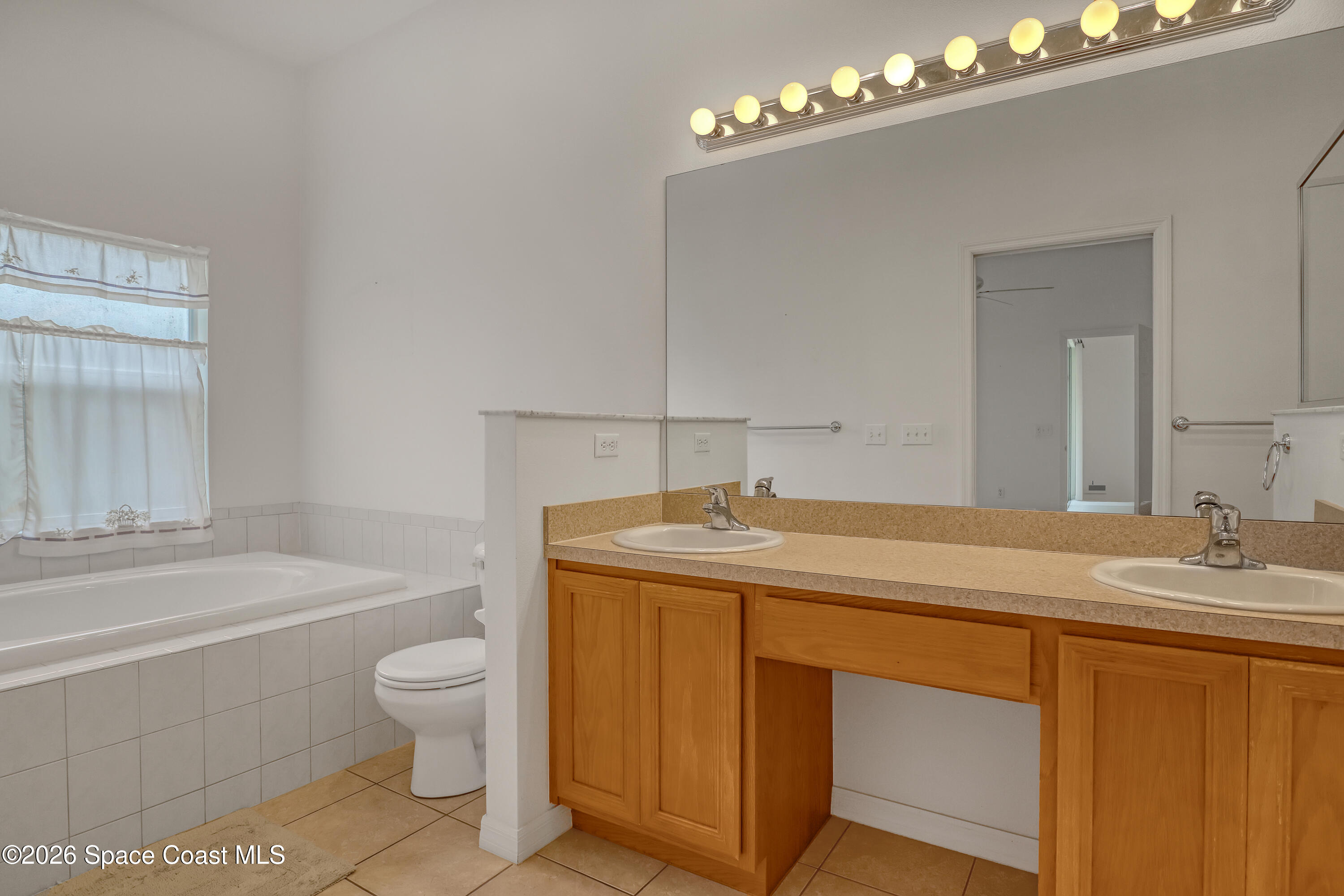 4892 Outlook Drive Melbourne, FL 32940 - Photo 19 of 34 a bathroom with a granite countertop sink toilet and a mirror