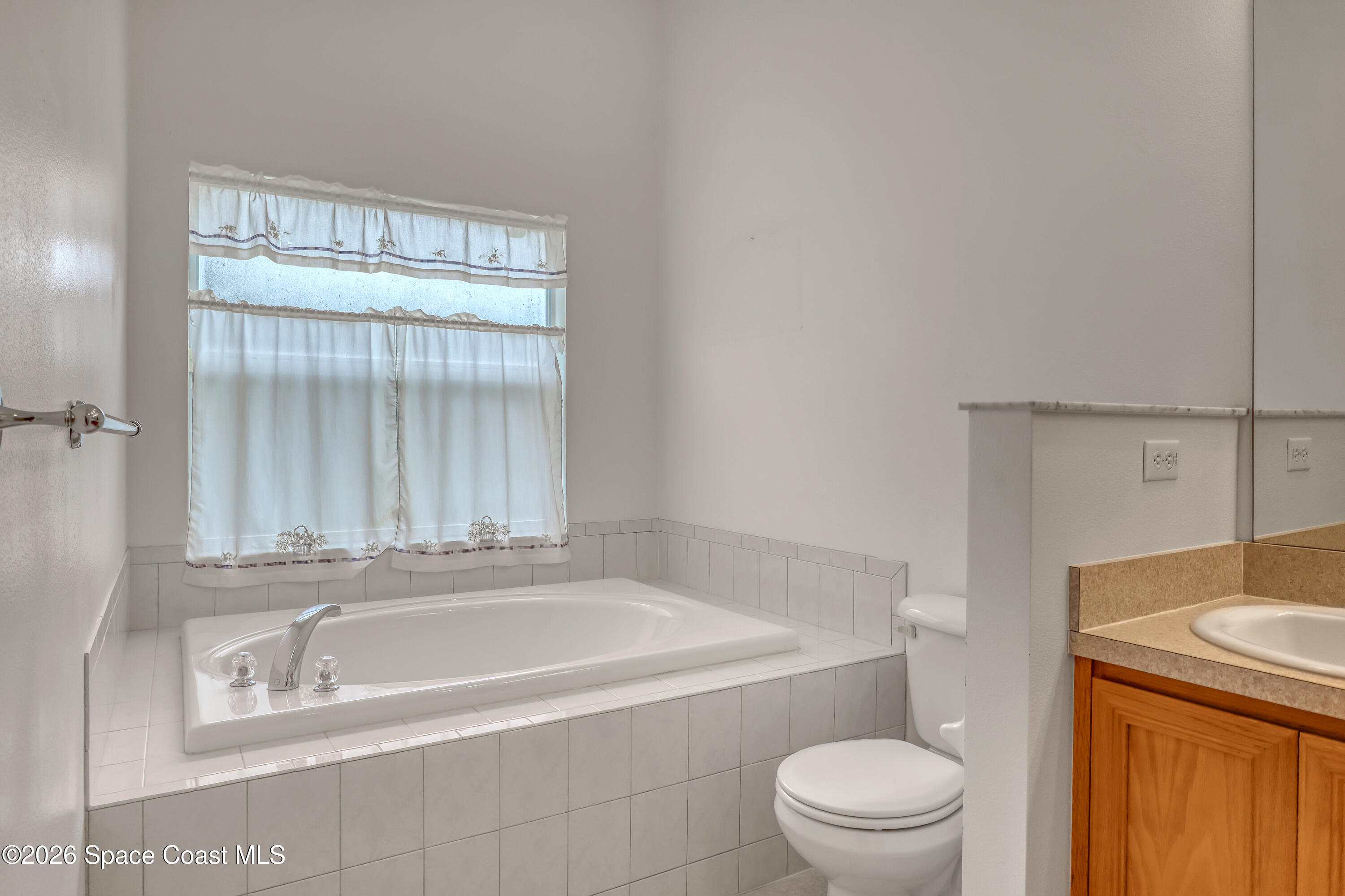 4892 Outlook Drive Melbourne, FL 32940 - Photo 20 of 34 a white bath tub sitting next to a toilet