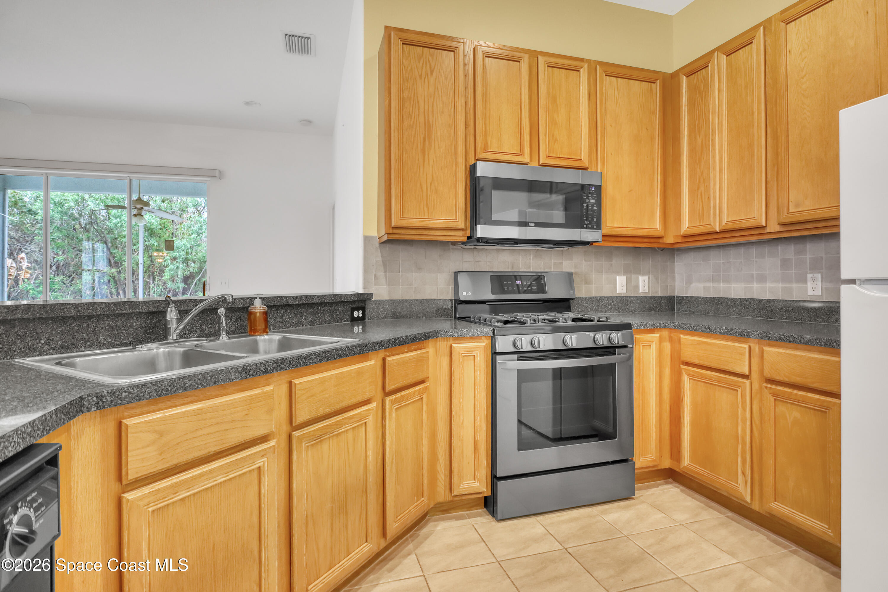 4892 Outlook Drive Melbourne, FL 32940 - Photo 2 of 34 a kitchen with stainless steel appliances granite countertop a stove a sink and a microwave