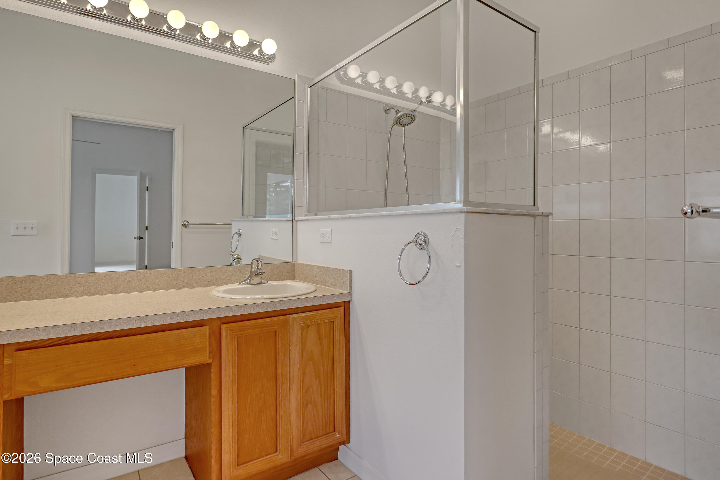 4892 Outlook Drive Melbourne, FL 32940 - Photo 21 of 34 a bathroom with a granite countertop sink a mirror and shower