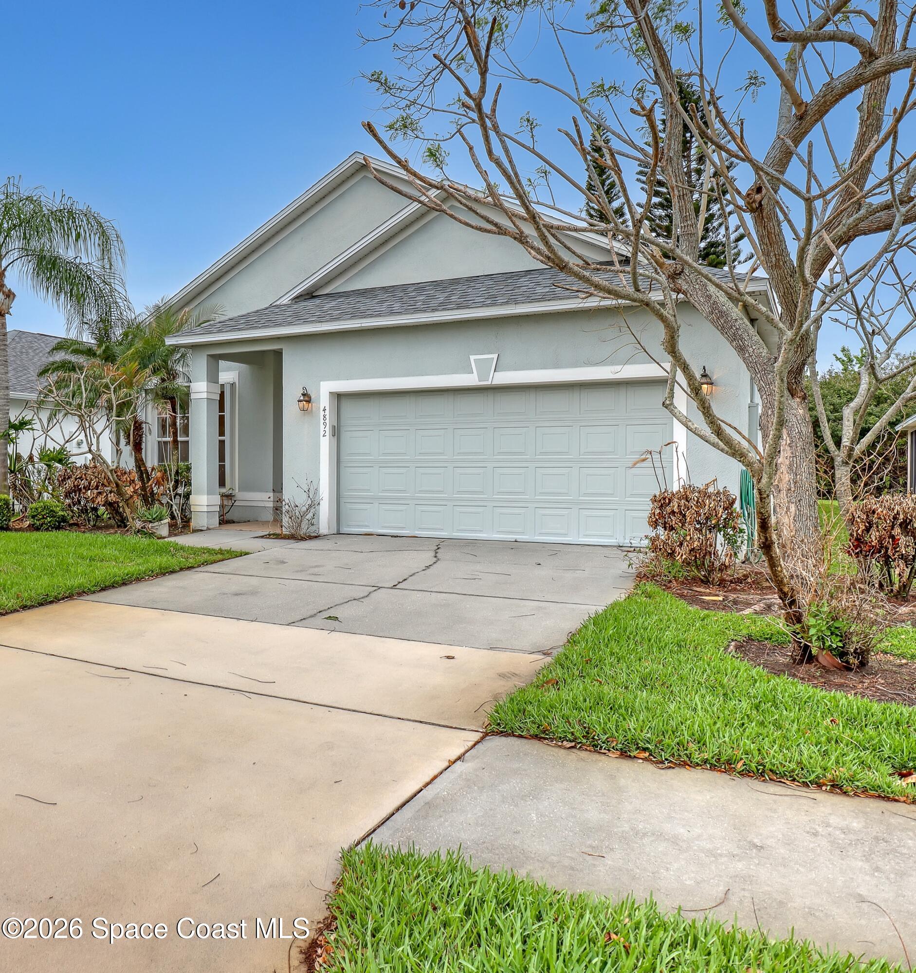 4892 Outlook Drive Melbourne, FL 32940 - Photo 34 of 34 a front view of a house with a yard and garage