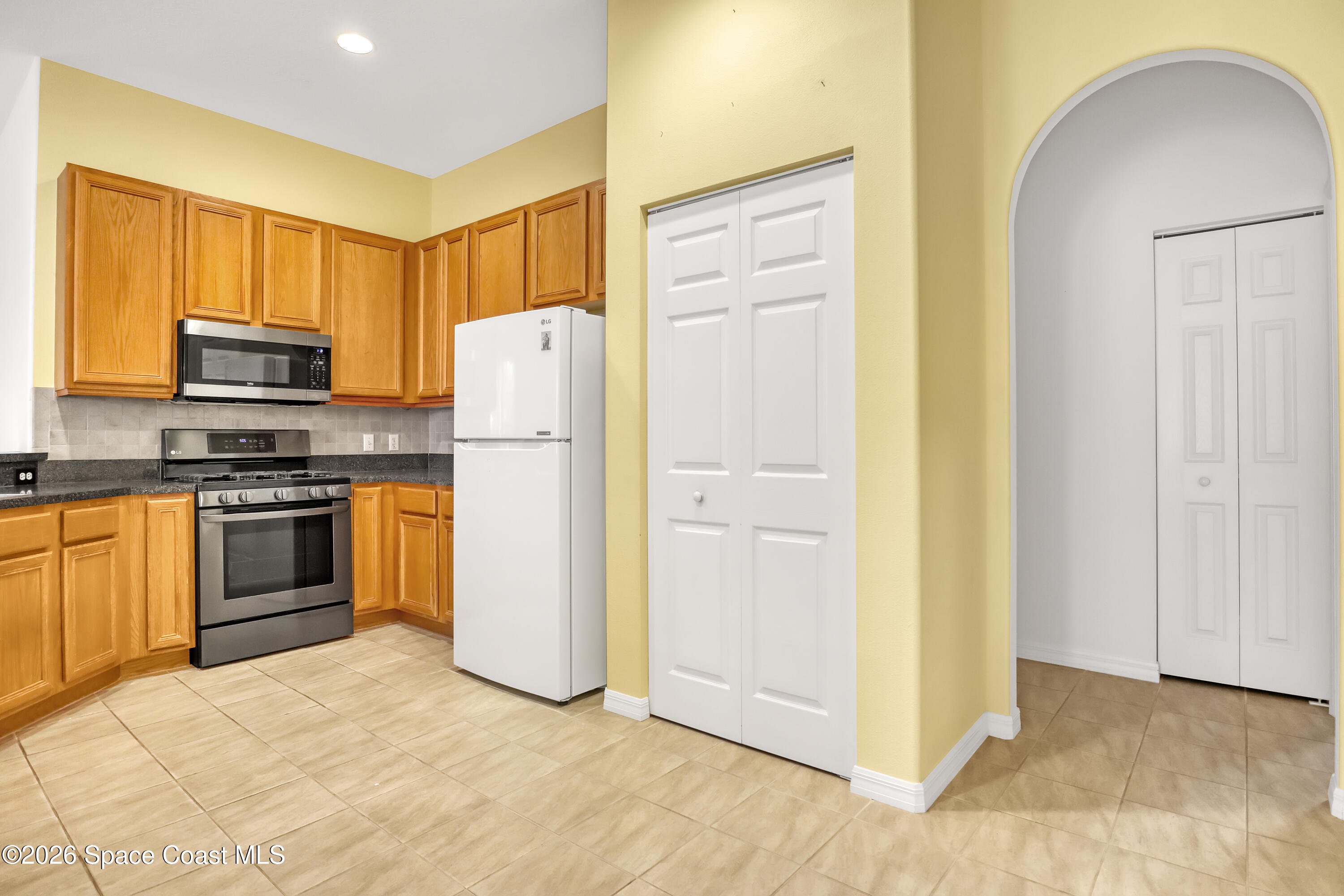 4892 Outlook Drive Melbourne, FL 32940 - Photo 5 of 34 a kitchen with a refrigerator a stove top oven and cabinets