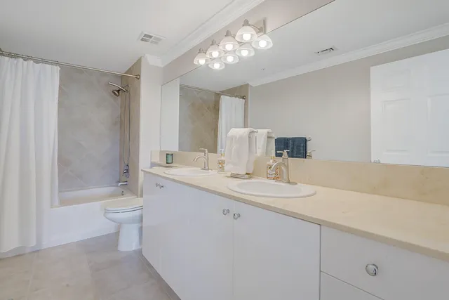 a bathroom with a double vanity sink toilet and shower
