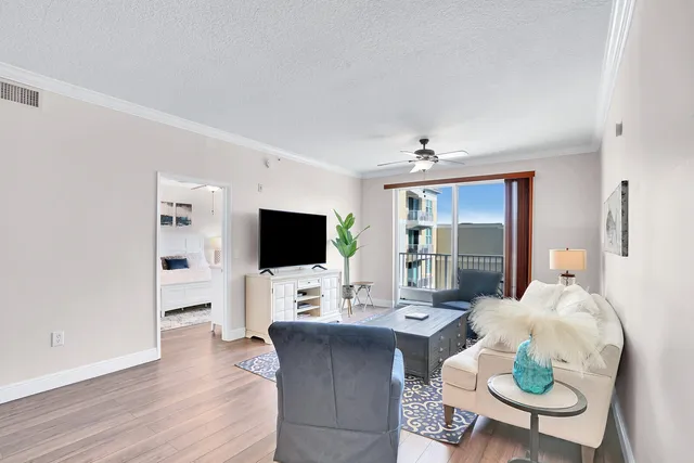 a living room with furniture a flat screen tv and a large window