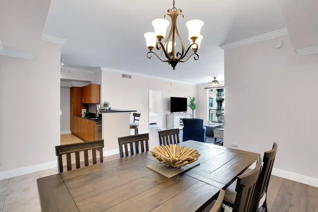 a view of a dining room with furniture a chandelier and wooden floor
