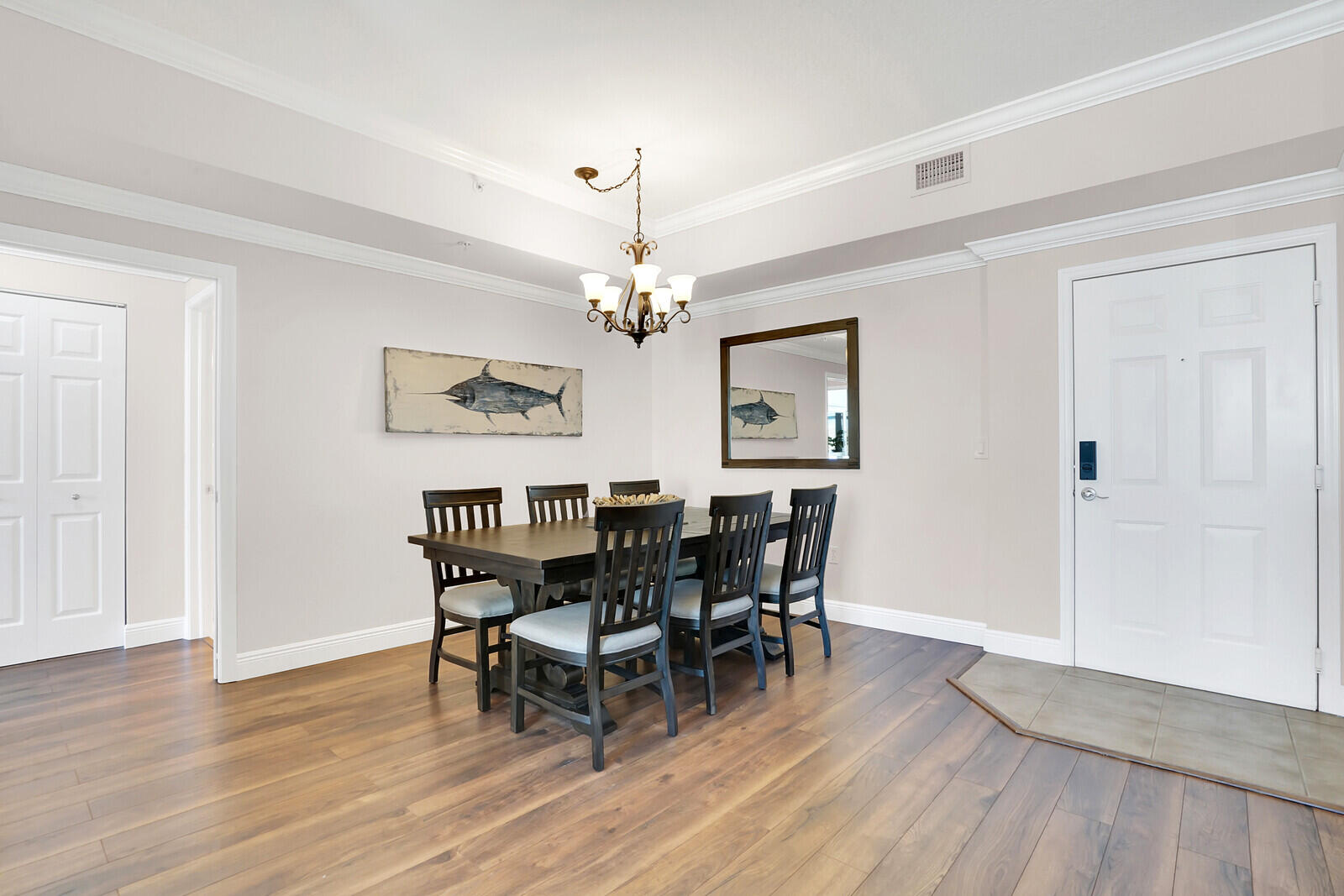 804 East Windward Way, Unit 608 Lantana, FL 33462 - Photo 9 of 33 a dining room with wooden floor a chandelier a wooden table and chairs