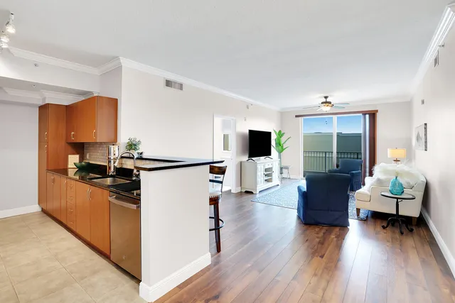 a kitchen with stainless steel appliances kitchen island wooden floors and refrigerator