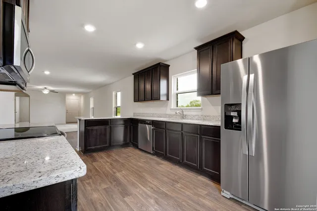 a large kitchen with a large counter top stainless steel appliances and cabinets