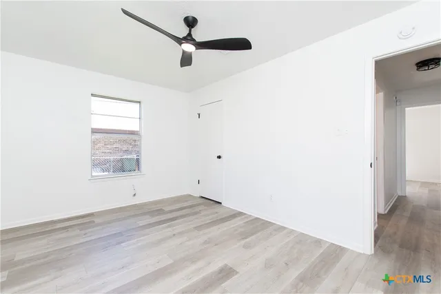 a view of empty room with wooden floor