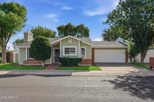 a view of a house with a yard and large tree