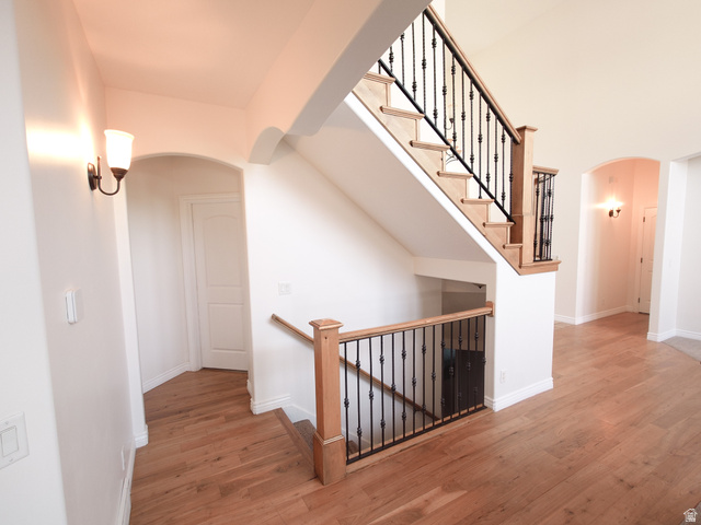 552 Sunset Crest Way Draper, UT 84020 - Photo 15 of 68 Hallway with arched walkways, light wood-type flooring, and an upstairs landing
