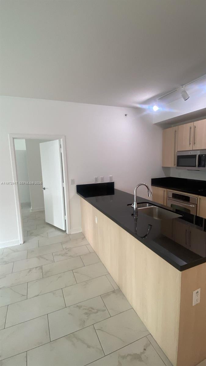 1111 Southwest 1st Avenue, Unit 2016N Miami, FL 33130 - Photo 5 of 20 a large kitchen with granite countertop a sink and a stove top oven