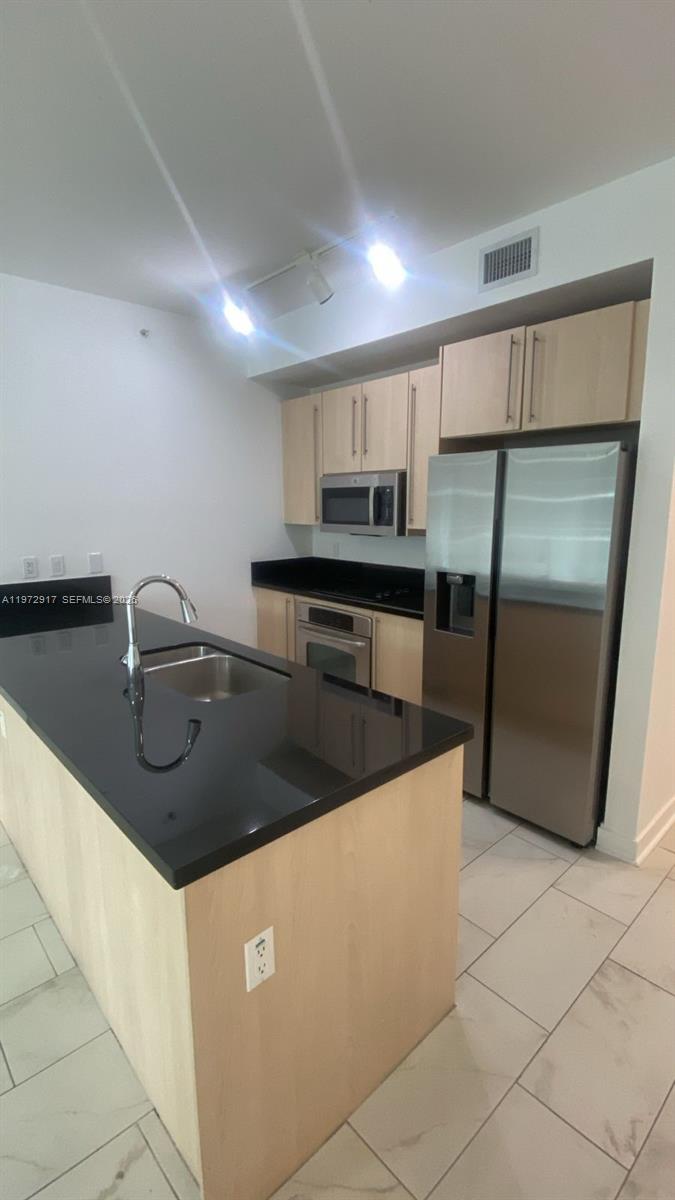 1111 Southwest 1st Avenue, Unit 2016N Miami, FL 33130 - Photo 7 of 20 a kitchen with stainless steel appliances granite countertop a sink and a stove