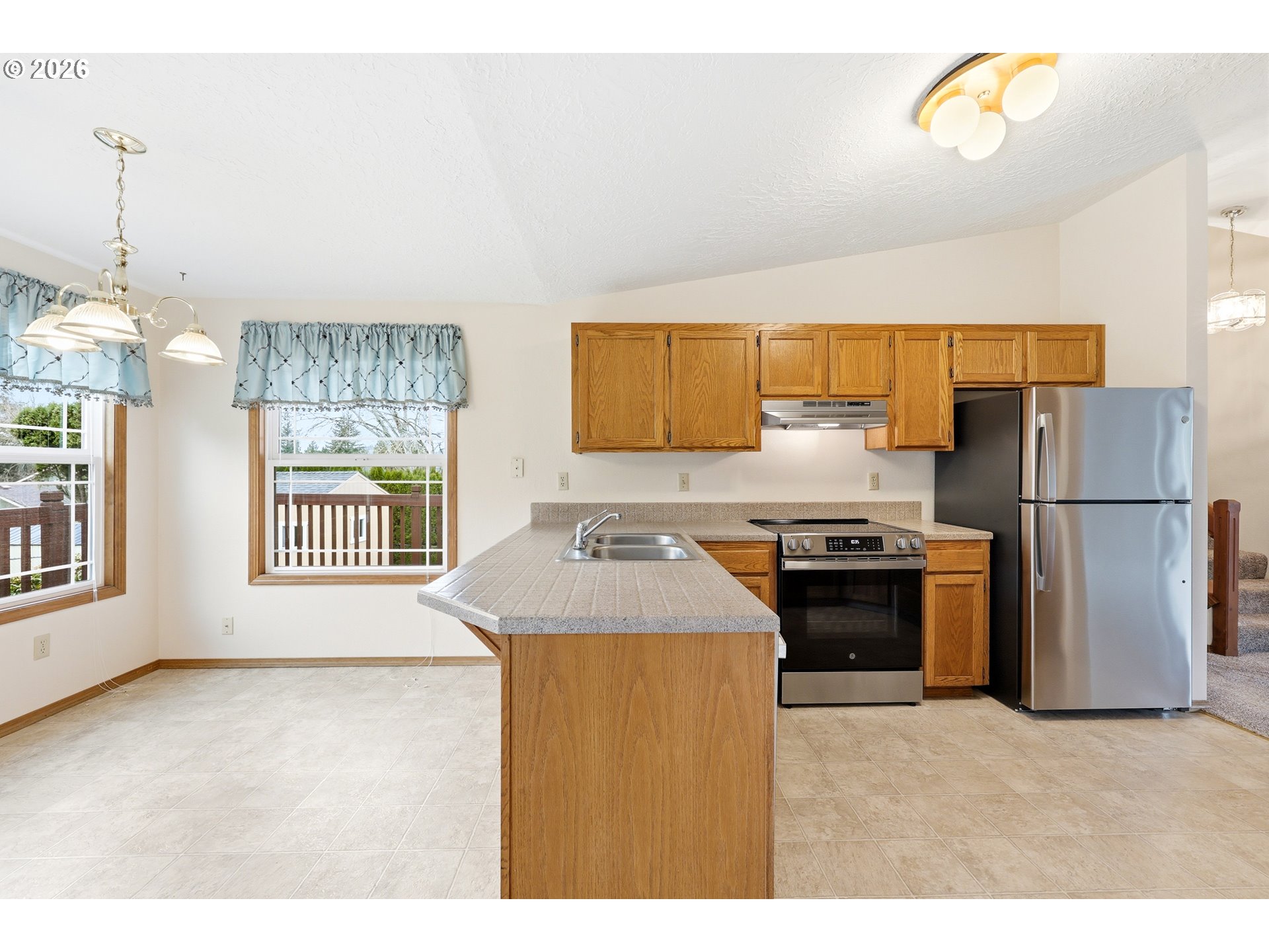 419 Southwest Day Court Gresham, OR 97080 - Photo 12 of 44 a kitchen with a refrigerator a stove a sink and a window