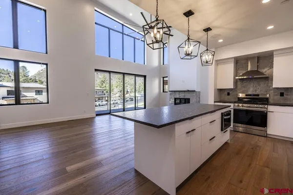 a kitchen that has a sink a stove and a microwave
