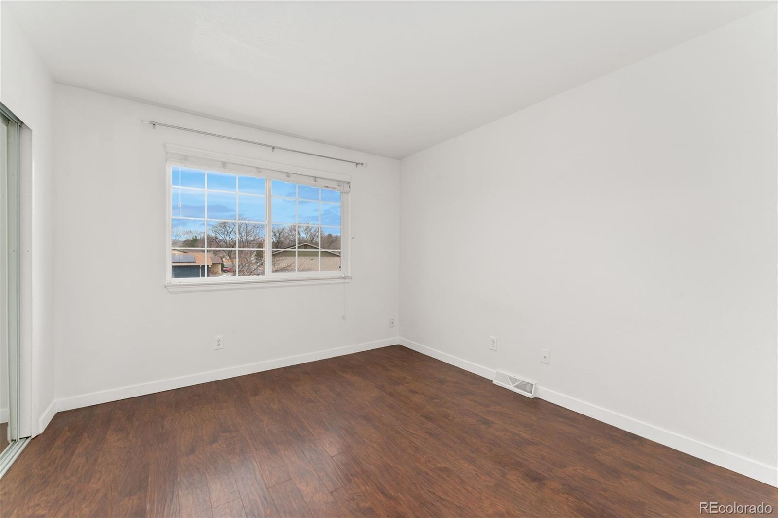 8919 Field Street, Unit 131 Broomfield, CO 80021 - Photo 12 of 27 a view of an empty room with wooden floor and a window