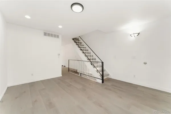 an empty room with staircase and white walls
