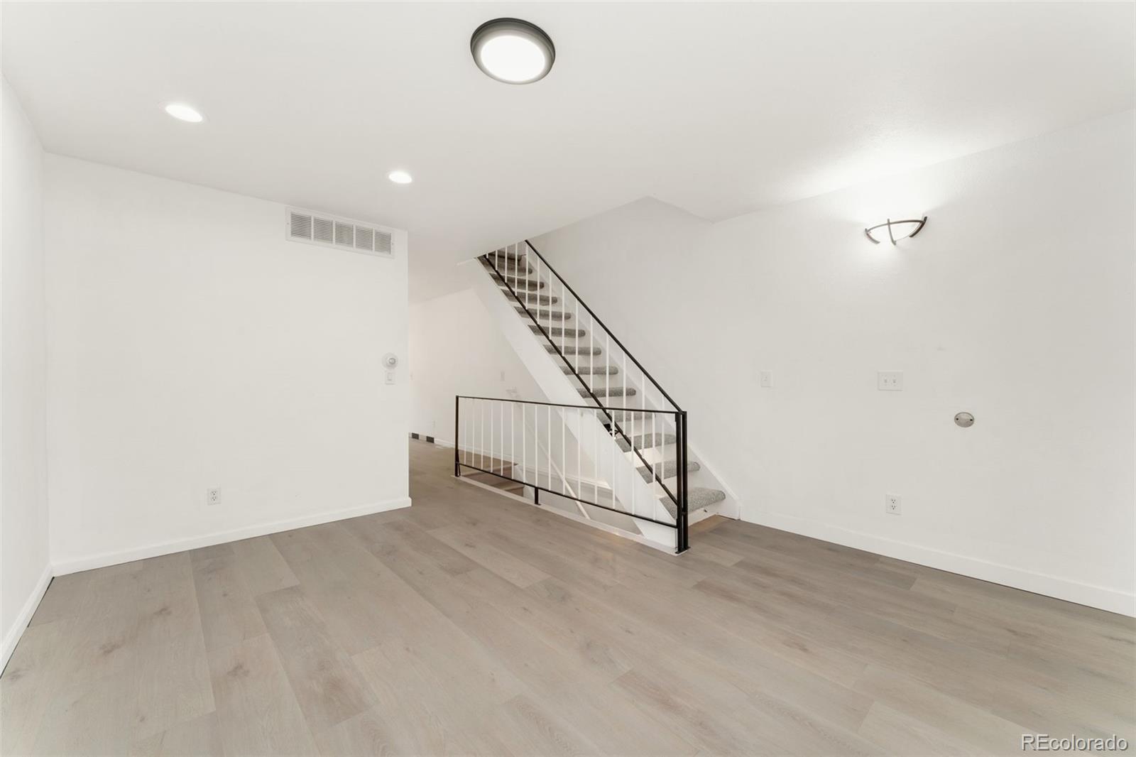 8919 Field Street, Unit 131 Broomfield, CO 80021 - Photo 4 of 27 an empty room with staircase and white walls