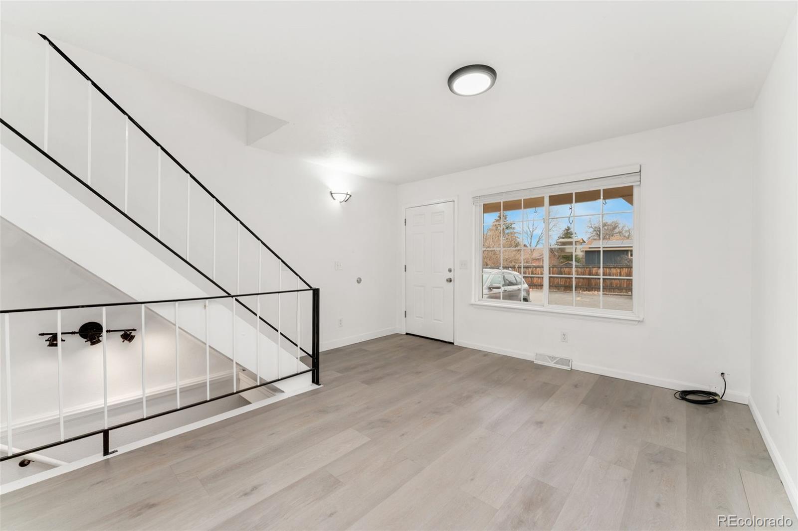 8919 Field Street, Unit 131 Broomfield, CO 80021 - Photo 5 of 27 an empty room with wooden floor and windows